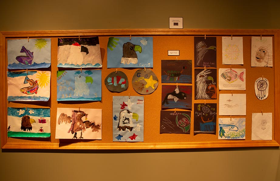 Cork board with childrens' drawings in a classroom at Hibulb Cultural Center