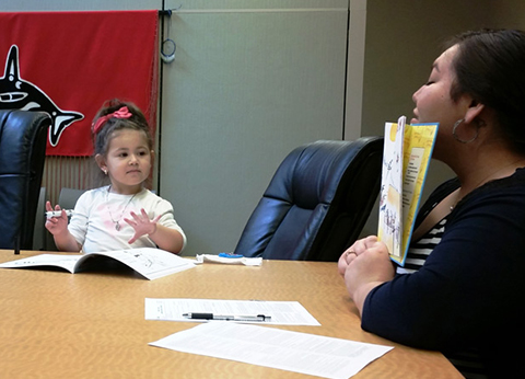 Nallely Flores reading her favorite stories to children in the library at Hibulb Cultural Center in Tulalip.